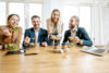 Group of a young office workers eating salads and drinking